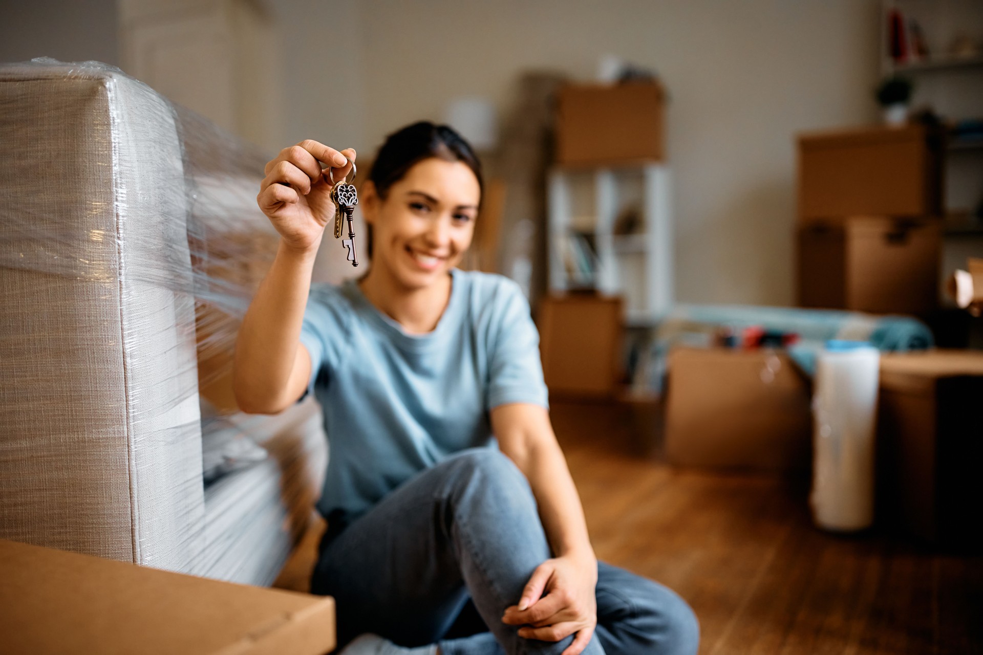 Close up of woman holding key while moving into a new home.